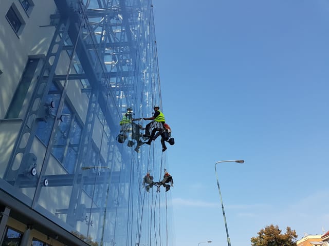 Washing the glass facade on a rope